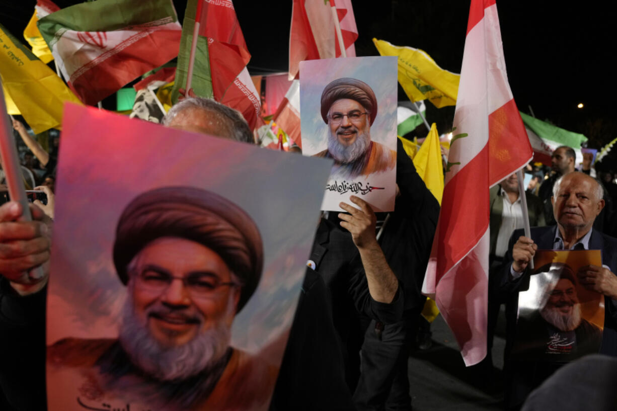 Iranian demonstrators hold posters of slain Hezbollah leader Hassan Nasrallah during an anti-Israeli protest at Felestin (Palestine) Square in Tehran, Iran, Tuesday, Oct. 1, 2024.