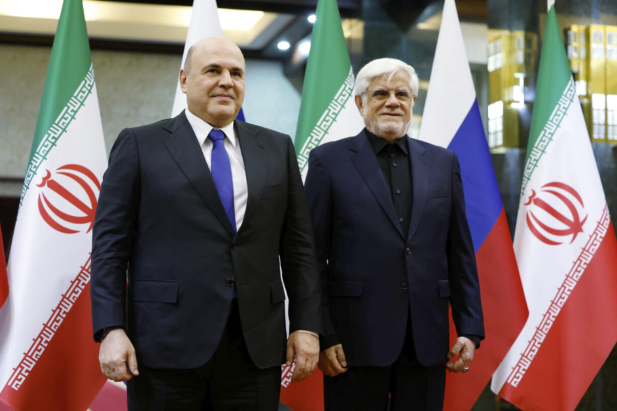 Russian Prime Minister Mikhail Mishustin, left, and Iranian First Vice President Mohammad Reza Aref pose for photos before a meeting in Tehran, Iran, Monday, Sept. 30, 2024.