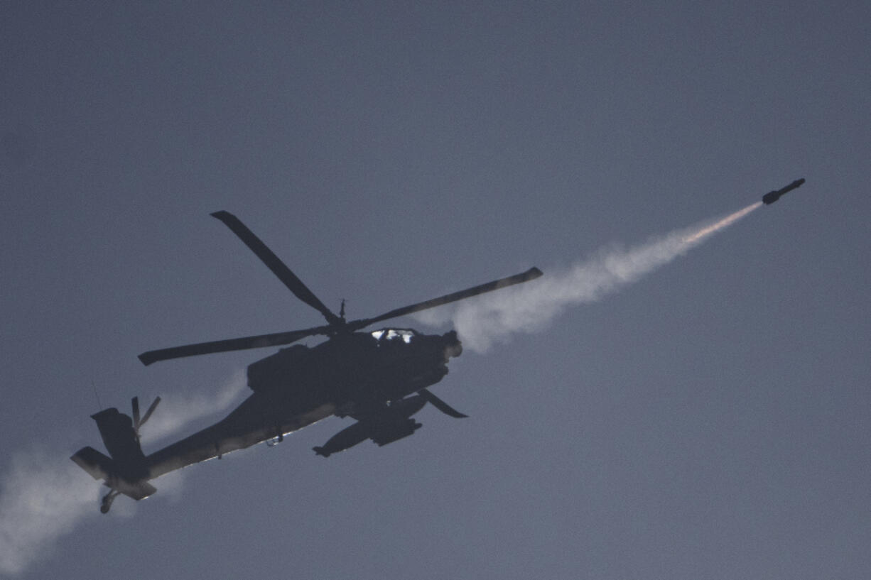 An Israeli Apache helicopter fires a missile towards southern Lebanon as seen from northern Israel, Sunday, Oct. 13, 2024.