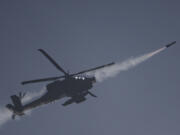 An Israeli Apache helicopter fires a missile towards southern Lebanon as seen from northern Israel, Sunday, Oct. 13, 2024.