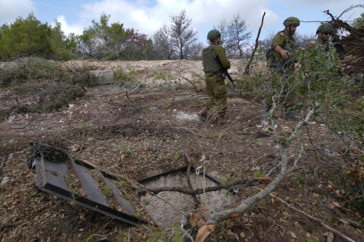 Israeli soldiers display what they say is an entrance to a Hezbollah tunnel found during their ground operation in southern Lebanon, near the border with Israel, Sunday, Oct. 13, 2024.