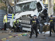 Israeli police and rescue services inspect the site where a truck driver rammed into a bus stop near the headquarters of Israel&#039;s Mossad spy agency, wounding dozens of people, according to Israel&#039;s Magen David Adom rescue service in Tel Aviv, Israel, Sunday, Oct. 27, 2024.