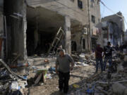 Palestinians examine the damage following an Israeli airstrike in the West Bank city of Tulkarem, which Palestinian health officials say killed 18 people and the Israeli military says took out a Hamas leader, on Friday, Oct. 4, 2024.