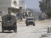 Israeli army units secure the parameter of the Nur Shams refugee camp during the ongoing army operation, after the Palestinian Health Ministry said two Palestinians were killed in an Israeli strike and a third by Israeli gunfire, in the West Bank city of Tulkarem Thursday, Oct. 31, 2024.