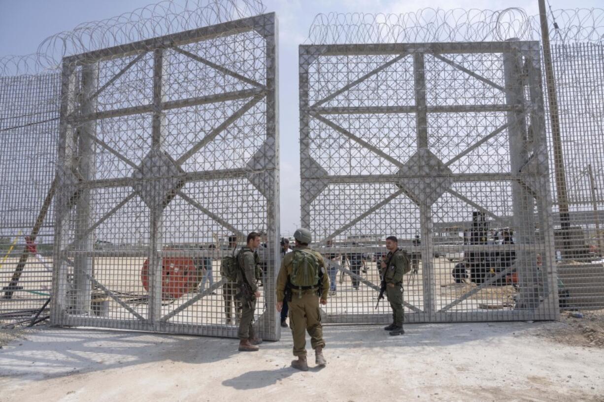 FILE - Israeli soldiers gather near a gate to walk through an inspection area for trucks carrying humanitarian aid supplies bound for the Gaza Strip, on the Israeli side of the Erez crossing into northern Gaza, on May 1, 2024.