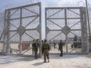 FILE - Israeli soldiers gather near a gate to walk through an inspection area for trucks carrying humanitarian aid supplies bound for the Gaza Strip, on the Israeli side of the Erez crossing into northern Gaza, on May 1, 2024.