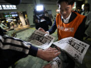 A worker of the Yomiuri Shimbun newspaper hands out copies of an extra version to passersby in Tokyo, Friday, Oct. 11, 2024, after Nihon Hidankyo, or the Japan Confederation of A- and H-Bomb Sufferers Organizations, won the Nobel Peace Prize.