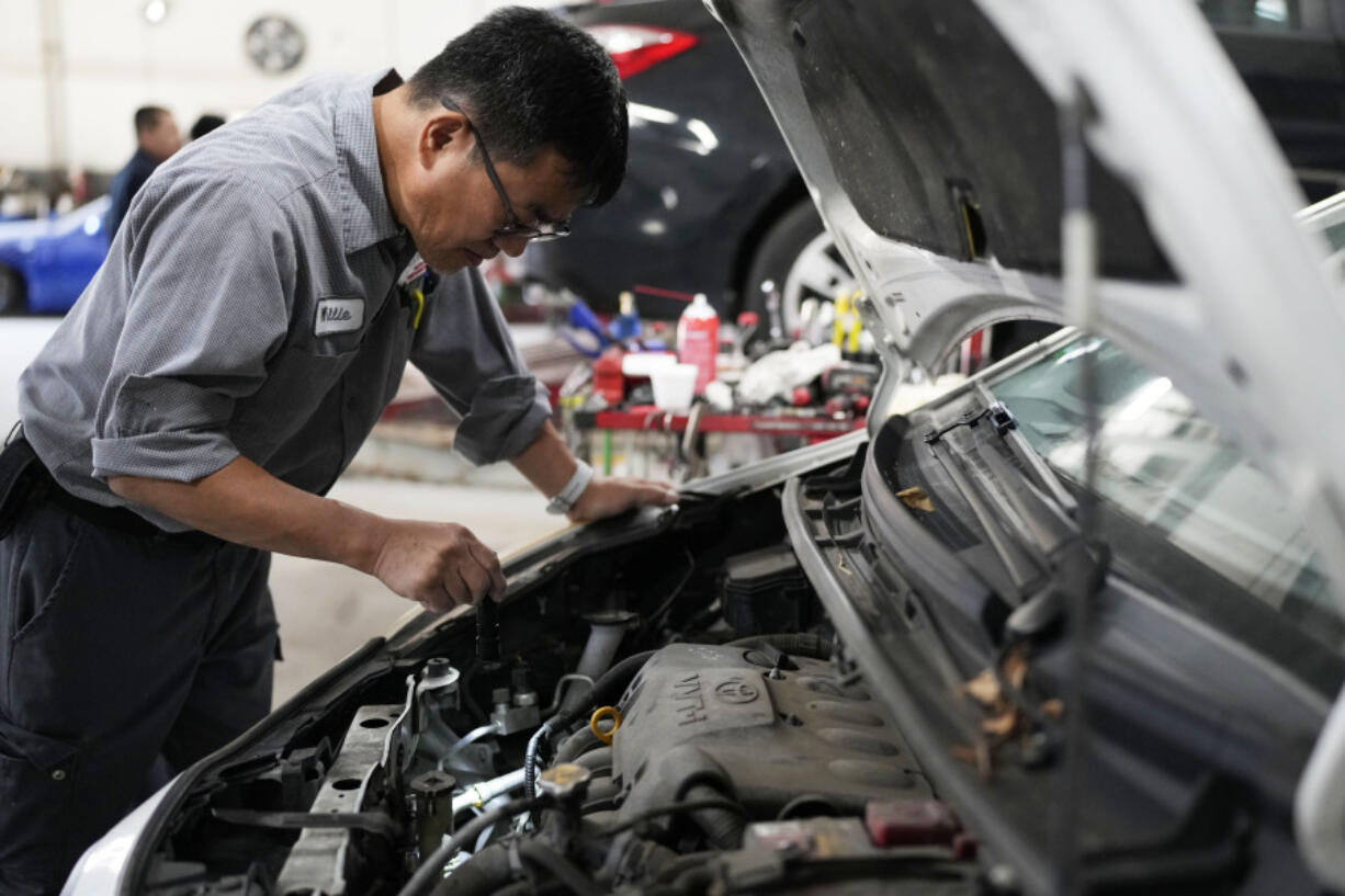 Auto mechanic Willie Chung works on a vehicle at the Express Auto Service Inc., in Chicago, Thursday, Sept. 19, 2024. (AP Photo/Nam Y.