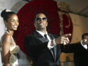 Sean &ldquo;P. Diddy&rdquo; Combs directs photographers Nov. 4, 2004, as they sing &ldquo;Happy Birthday,&rdquo; to him as his date Kim Porter, left, listens, after Combs arrived for his 35th birthday celebration at Cipriani on Wall Street in New York.