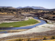 FILE - The Klamath River flows where Iron Gate Reservoir once was as work to remove of the Iron Gate and Copco Dams continues on the Klamath River near Hornbook, Calif., July 25, 2024.