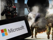 FILE - The logo for Microsoft, and a scene from Activision &ldquo;Call of Duty - Modern Warfare,&rdquo; are shown in this photo, in New York, June 21, 2023.