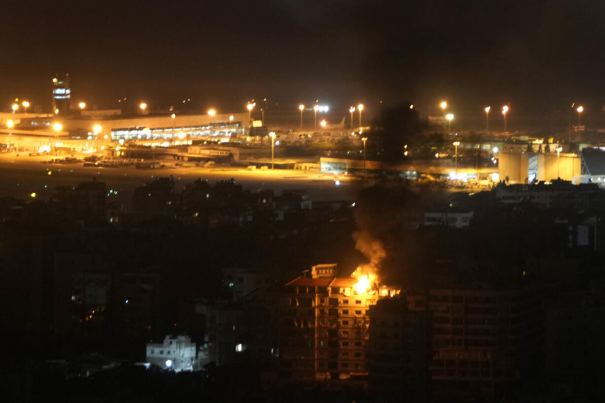 Flames and smoke rise from a building that was hit by an Israeli airstrike in Dahiyeh, as Rafik Hariri International airport is seen in the background, in Beirut, Lebanon, Friday, Oct. 4, 2024.