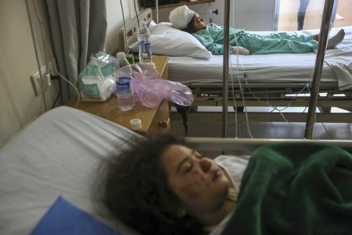 Yasmina Khalifa, background, and her sister, Julia, who were injured in an Israeli airstrike that hit their building Tuesday night, lie in hospital beds Wednesday in Sarafand, southern Lebanon.