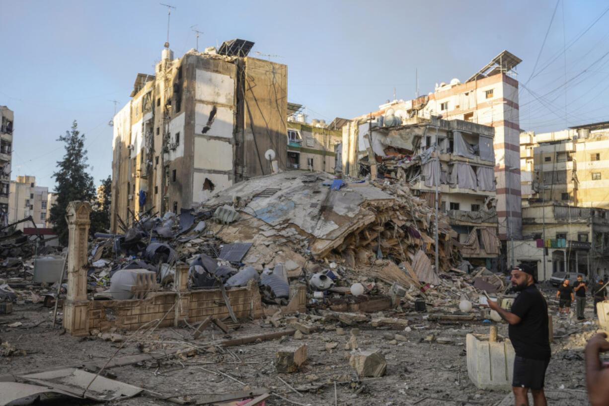 A man documents the damaged buildings at the site of an Israeli airstrike in Dahiyeh, Beirut, Lebanon, Friday, Oct. 4, 2024.