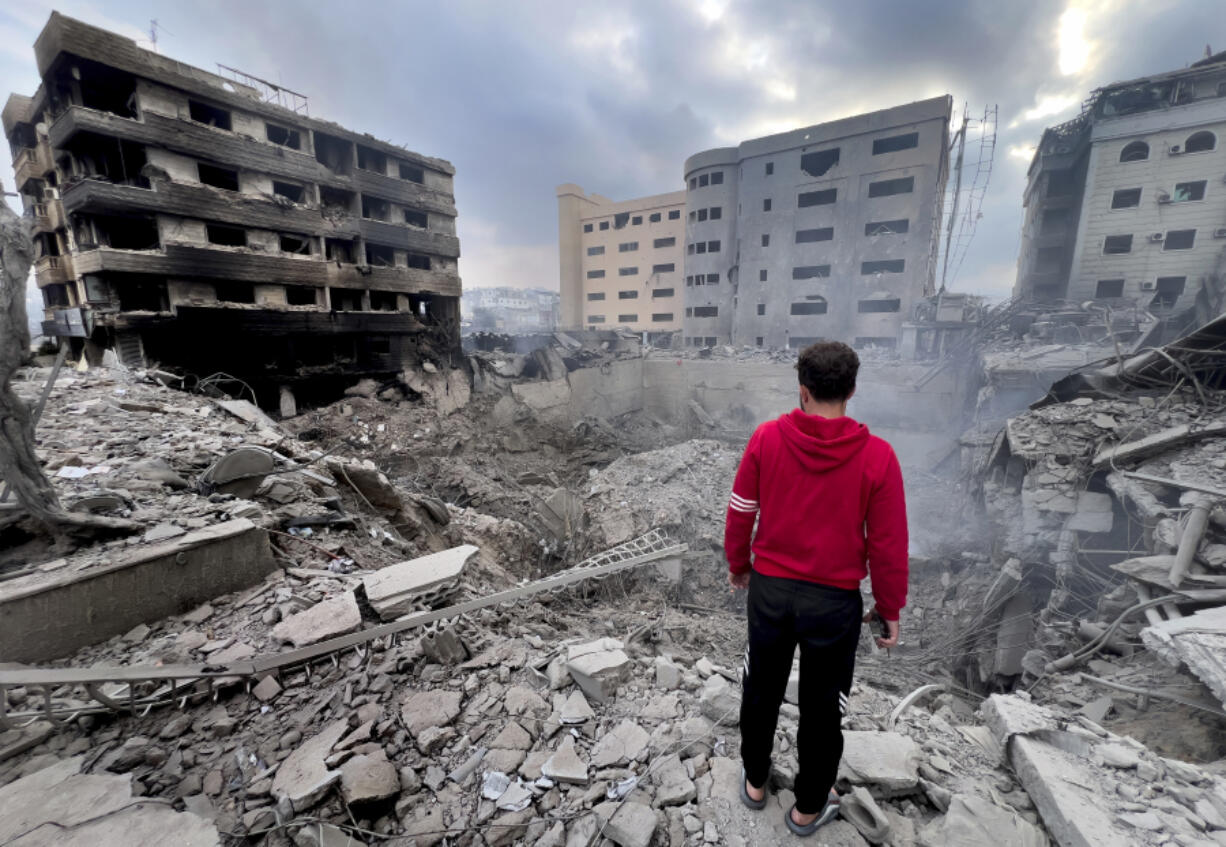 FILE - A man looks at destroyed buildings hit by Israeli airstrikes in Dahiyeh, Beirut, Lebanon, Monday, Oct. 7, 2024. Now in Lebanon, the Israeli military tells residents that they live near &ldquo;facilities and interests&rdquo; belonging to the militant Hezbollah group that they will strike soon. These warnings often come ahead of a series of overnight strikes on buildings in the Beirut southern suburbs, though there often are far more strikes than warned about.