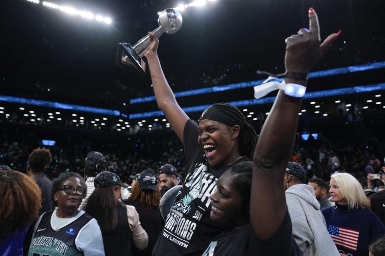 New York Liberty forward Jonquel Jones, left, holds up the MVP award after the Liberty defeated the Minnesota Lynx in Game 5 of the WNBA basketball final series, Sunday, Oct. 20, 2024, in New York.