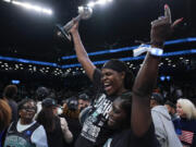 New York Liberty forward Jonquel Jones, left, holds up the MVP award after the Liberty defeated the Minnesota Lynx in Game 5 of the WNBA basketball final series, Sunday, Oct. 20, 2024, in New York.