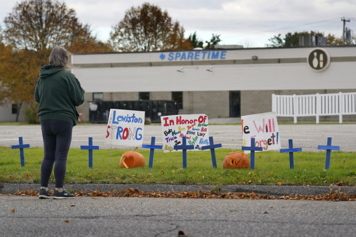 FILE - A woman visits a makeshift memorial outside Sparetime Bowling Alley, the site of a mass shooting, Oct. 28, 2023, in Lewiston, Maine. (AP Photo/Robert F.