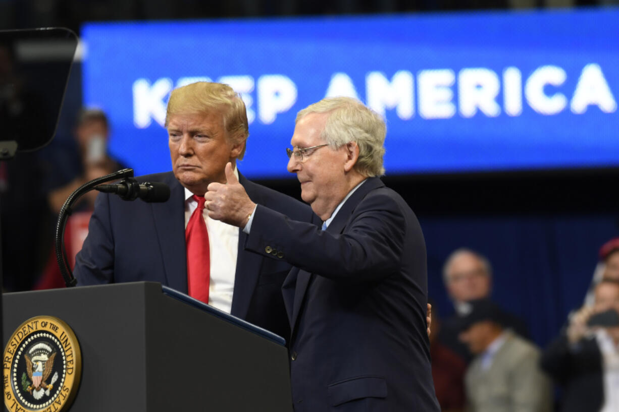 FILE - President Donald Trump brings Senate Majority Leader Mitch McConnell of Ky., on stage during a campaign rally in Lexington, Ky., Nov. 4, 2019.