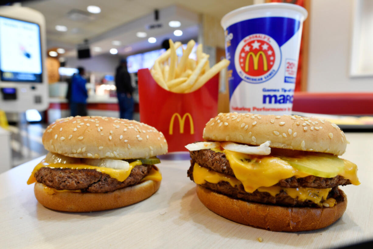 FILE- In this March 6, 2018, file photo, a McDonald&#039;s Quarter Pounder, left, and Double Quarter Pound burger is shown in Atlanta.