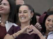 FILE - Presidential candidate Claudia Sheinbaum flashes a hand-heart sign during her closing campaign rally at the Zocalo in Mexico City, May 29, 2024. Sheinbaum, a climate scientist and former Mexico City mayor, will be sworn in as Mexico&rsquo;s first woman president on Oct. 1.