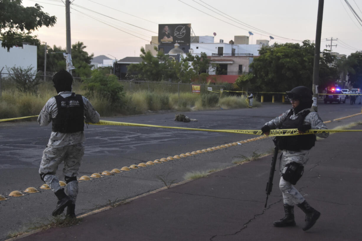 National Guards cordon off an area where a corpse lies on a street in Culiacan, Sinaloa state, Mexico, Monday, Oct. 14, 2024.