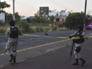 National Guards cordon off an area where a corpse lies on a street in Culiacan, Sinaloa state, Mexico, Monday, Oct. 14, 2024.