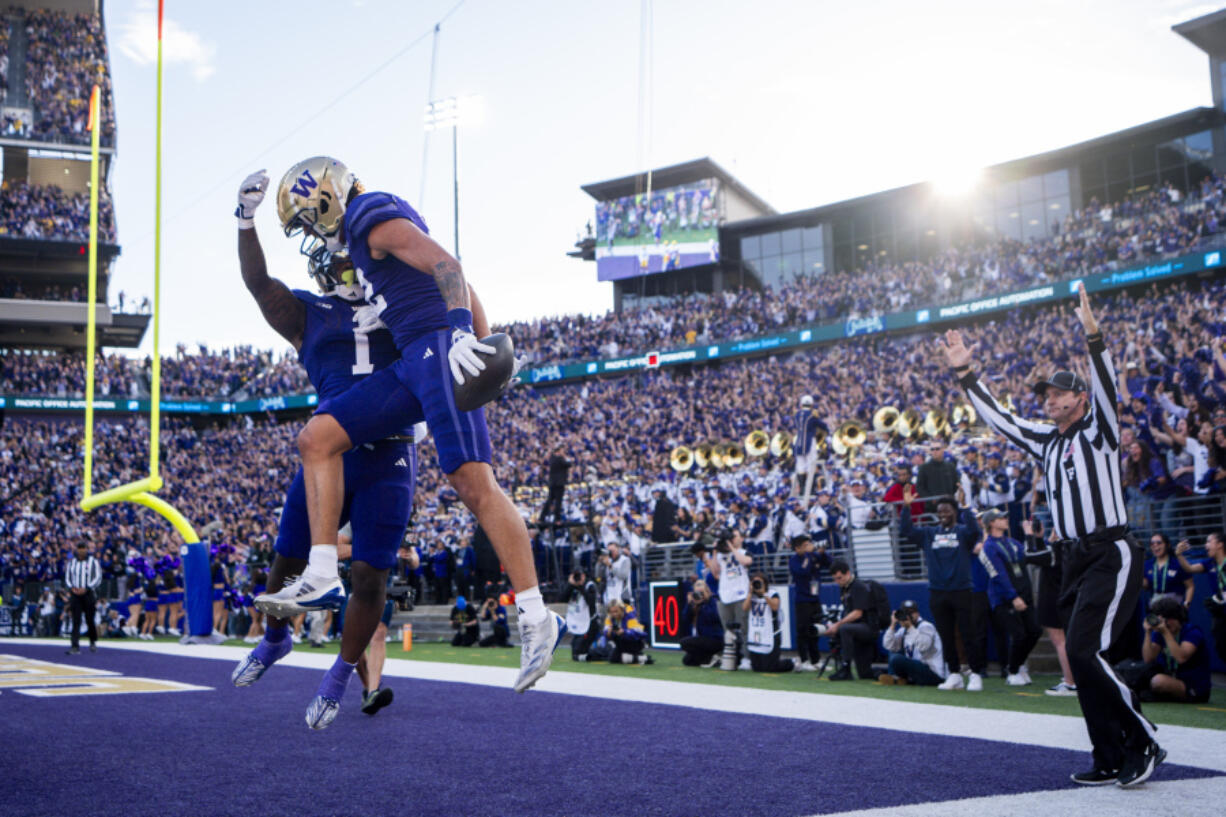 Washington wide receiver Denzel Boston, front, celebrates his touchdown with running back Jonah Coleman (1) during the first half of an NCAA college football game against Michigan, Saturday, Oct. 5, 2024, in Seattle.