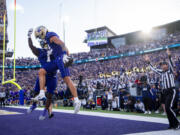 Washington wide receiver Denzel Boston, front, celebrates his touchdown with running back Jonah Coleman (1) during the first half of an NCAA college football game against Michigan, Saturday, Oct. 5, 2024, in Seattle.