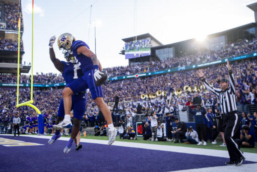 Washington wide receiver Denzel Boston, front, celebrates his touchdown with running back Jonah Coleman (1) during the first half of an NCAA college football game against Michigan, Saturday, Oct. 5, 2024, in Seattle.