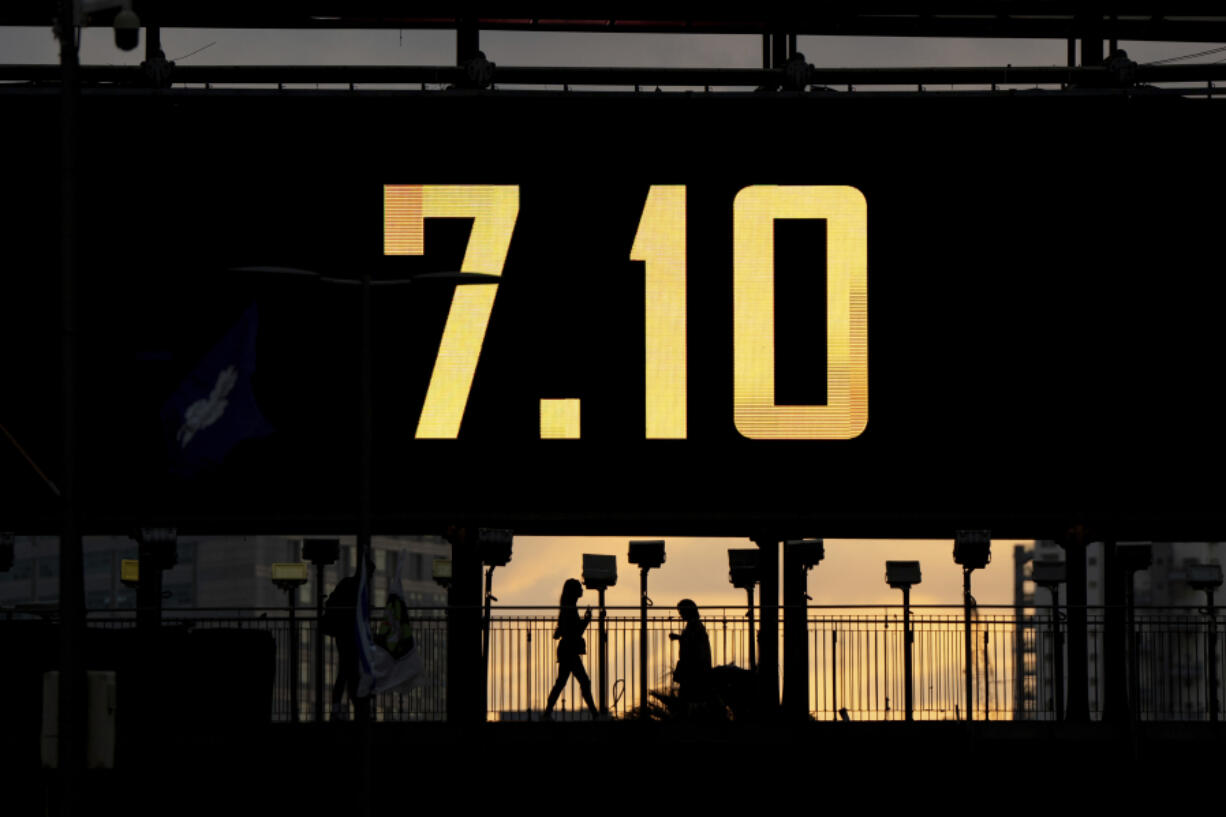 People cross a bridge with the date 7.10, marking the one-year anniversary of the Hamas attack on Israel, in Ramat Gan, Israel, Sunday, Oct. 6, 2024.