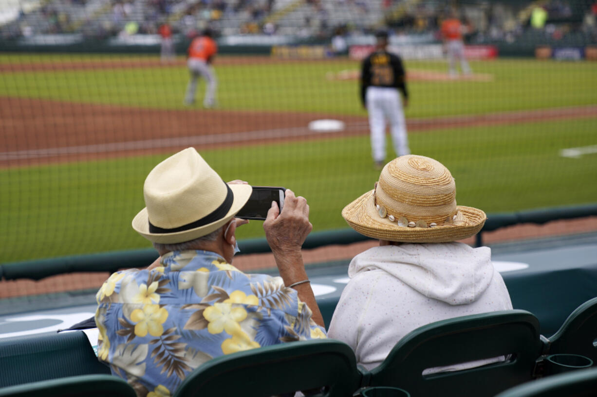 FILE - Baseball fans watch a spring training exhibition baseball game between the Pittsburgh Pirates and the Baltimore Orioles in Bradenton, Fla., March 22, 2021. (AP Photo/Gene J.