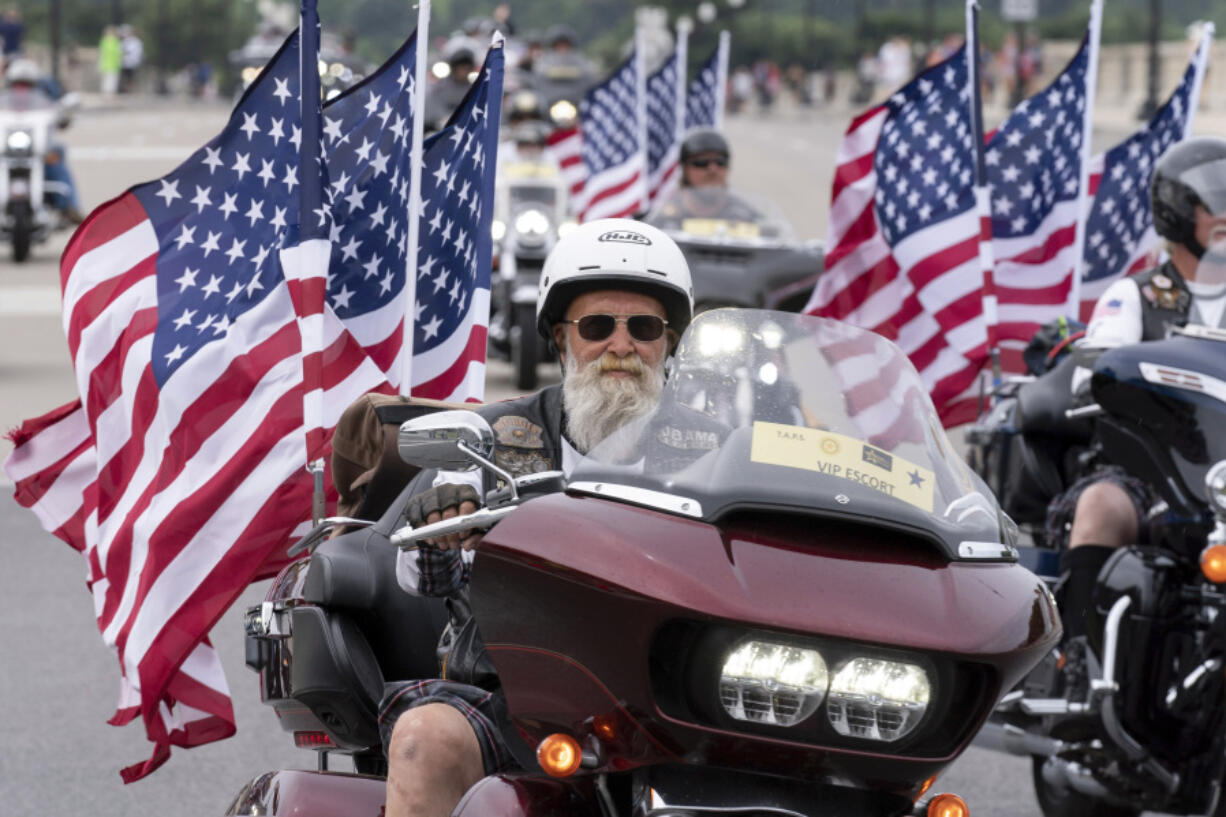 FILE - Participants in the &ldquo;Rolling to Remember&rdquo; motorcycle rally ride past Arlington Memorial Bridge during the annual motorcycle parade, ahead of Memorial Day, in Washington, Sunday, May 28, 2023.