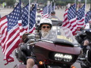 FILE - Participants in the &ldquo;Rolling to Remember&rdquo; motorcycle rally ride past Arlington Memorial Bridge during the annual motorcycle parade, ahead of Memorial Day, in Washington, Sunday, May 28, 2023.