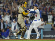 Los Angeles Dodgers&#039; Shohei Ohtani, right, collides with San Diego Padres catcher Kyle Higashioka as he scores on a single by Teoscar Hern&aacute;ndez during the fourth inning in Game 1 of baseball&#039;s NL Division Series Saturday, Oct. 5, 2024, in Los Angeles. (AP Photo/Mark J.