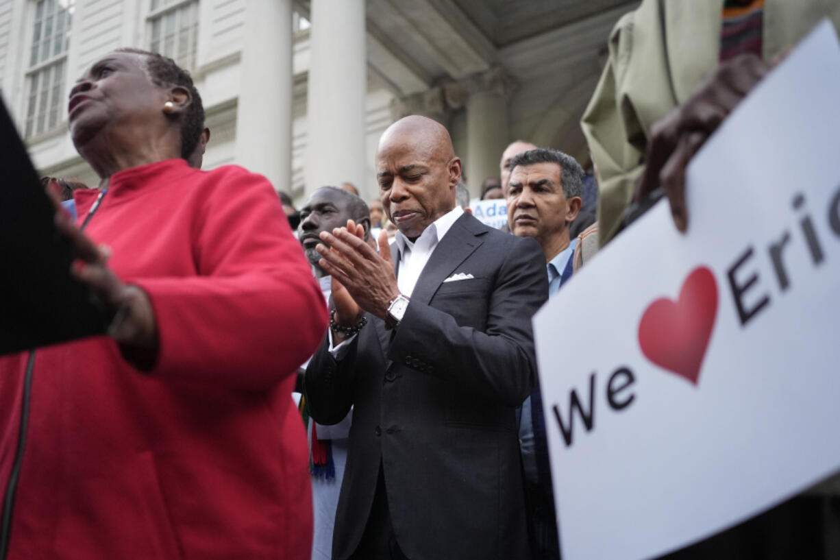 New York City Mayor Eric Adams, center, is surrounded by faith leaders and other supporters during a rally and prayer vigil on the steps of City Hall in New York, Tuesday, Oct. 1, 2024.