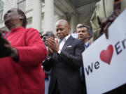 New York City Mayor Eric Adams, center, is surrounded by faith leaders and other supporters during a rally and prayer vigil on the steps of City Hall in New York, Tuesday, Oct. 1, 2024.