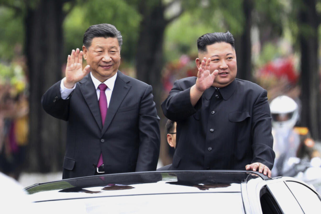 FILE - In this photo released by China&#039;s Xinhua News Agency, visiting Chinese President Xi Jinping, left, and North Korean leader Kim Jong Un wave from an open top limousine as they travel along a street in Pyongyang, North Korea, on June 20, 2019.