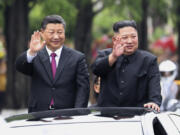 FILE - In this photo released by China&#039;s Xinhua News Agency, visiting Chinese President Xi Jinping, left, and North Korean leader Kim Jong Un wave from an open top limousine as they travel along a street in Pyongyang, North Korea, on June 20, 2019.