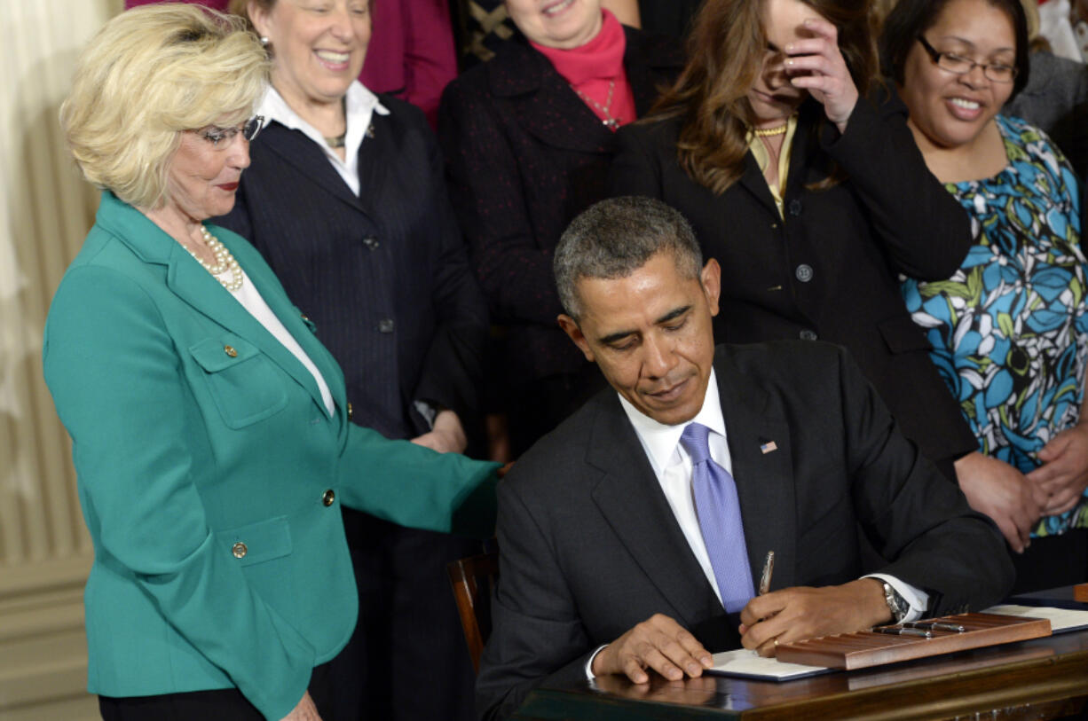 FILE - Lilly Ledbetter watches as President Barack Obama signs executive actions, with pending Senate legislation, aimed at closing a compensation gender gap that favors men, at the White House in Washington, April 8, 2014, during an event marking Equal Pay Day.