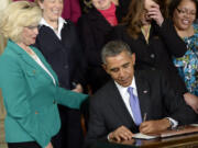 FILE - Lilly Ledbetter watches as President Barack Obama signs executive actions, with pending Senate legislation, aimed at closing a compensation gender gap that favors men, at the White House in Washington, April 8, 2014, during an event marking Equal Pay Day.