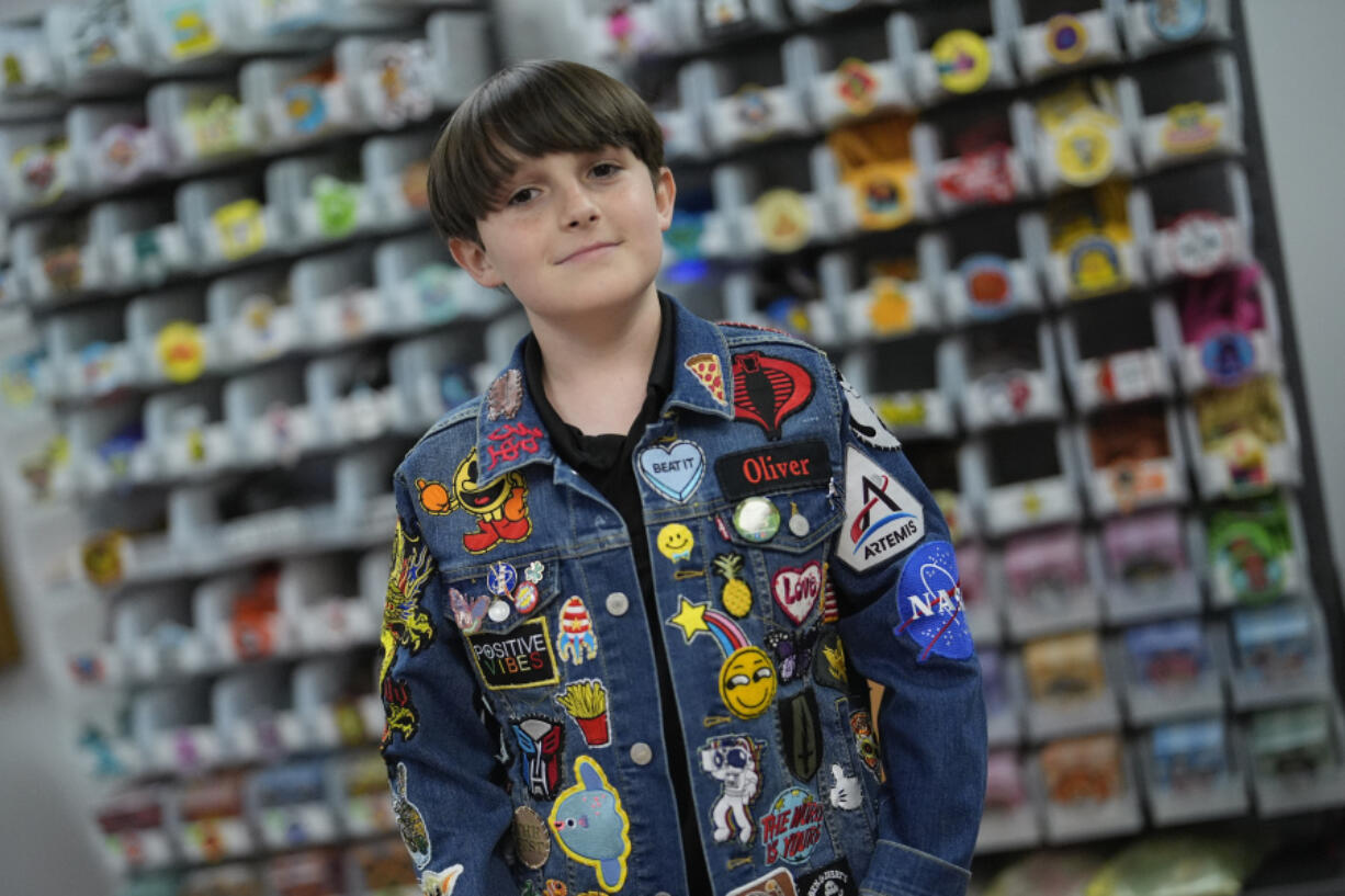 Oliver Burkhardt, 13, stands Sept. 4 in front of trays of patches inside the offices of the Oliver Patch Project in Miami.