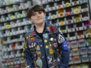 Oliver Burkhardt, 13, stands Sept. 4 in front of trays of patches inside the offices of the Oliver Patch Project in Miami.