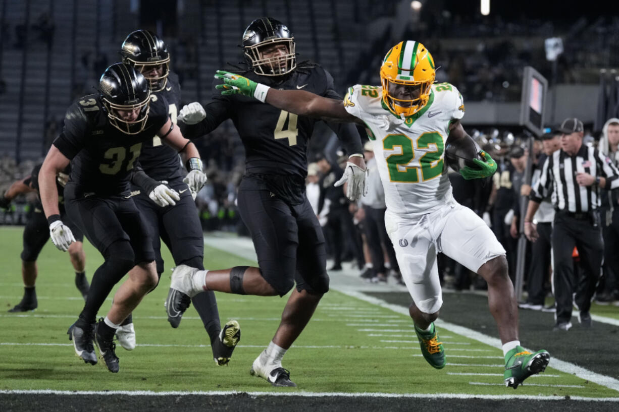 Oregon running back Jay Harris (22) scores a touchdown in front of Purdue linebacker Kydran Jenkins (4) during the second half of an NCAA college football game in West Lafayette, Ind., Friday, Oct. 18, 2024.