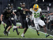 Oregon running back Jay Harris (22) scores a touchdown in front of Purdue linebacker Kydran Jenkins (4) during the second half of an NCAA college football game in West Lafayette, Ind., Friday, Oct. 18, 2024.