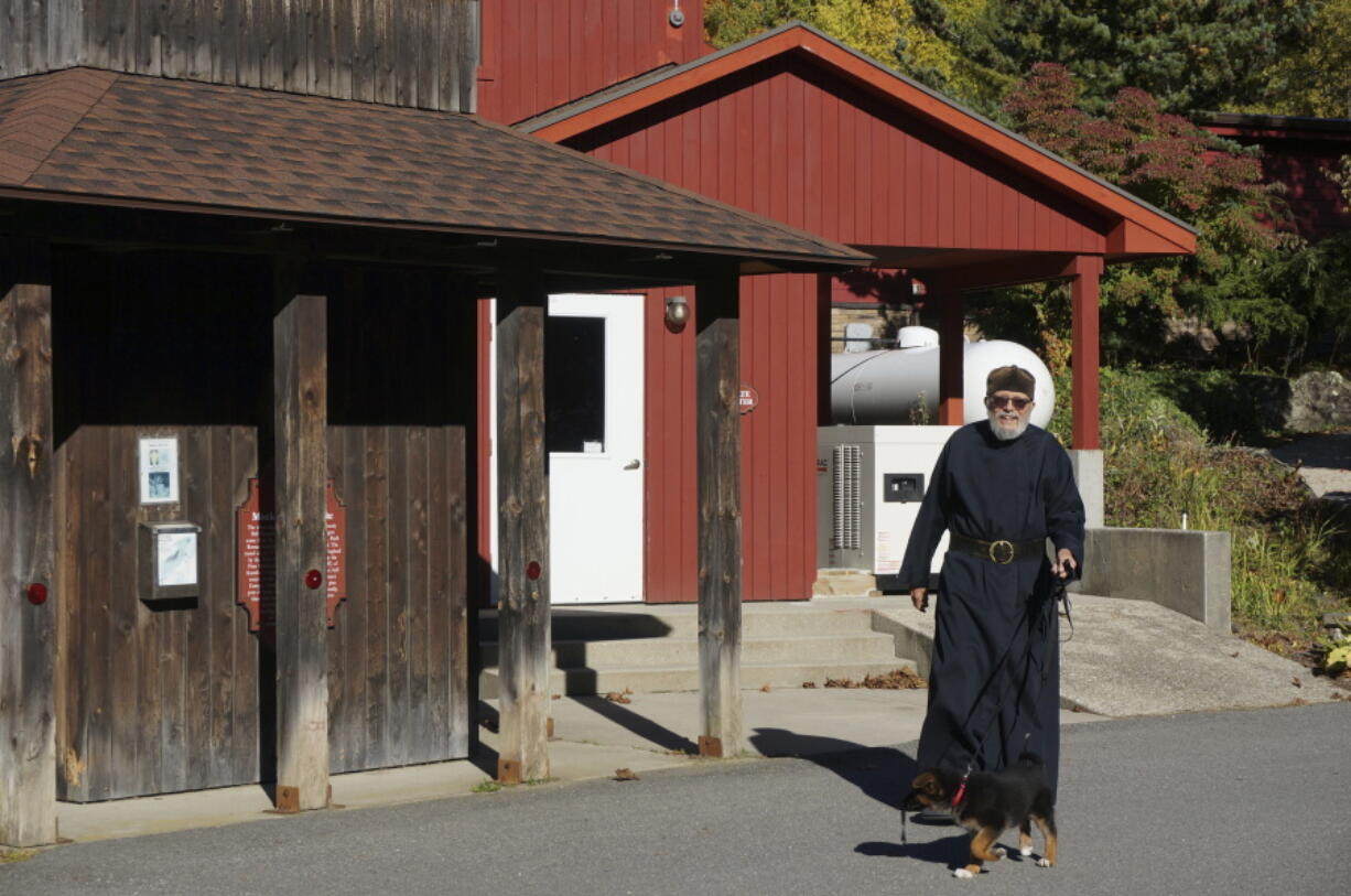 Brother Luke, an Orthodox Christian monk, walks his 10-week-old German shepherd Pyrena outside the residences of the New Skete monastery, where he directs the dog breeding program that has provided both financial and spiritual support to the community for decades outside Cambridge, N.Y., on Oct. 12, 2024.