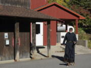 Brother Luke, an Orthodox Christian monk, walks his 10-week-old German shepherd Pyrena outside the residences of the New Skete monastery, where he directs the dog breeding program that has provided both financial and spiritual support to the community for decades outside Cambridge, N.Y., on Oct. 12, 2024.