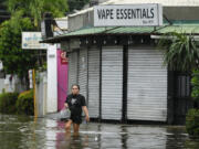 A resident crosses flooded streets caused by Tropical Storm Trami on Friday, Oct. 25, 2024, in Cainta, Rizal province, Philippines.