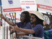 Dockworkers from Port Miami display signs at a picket line, Thursday, Oct. 3, 2024, in Miami.