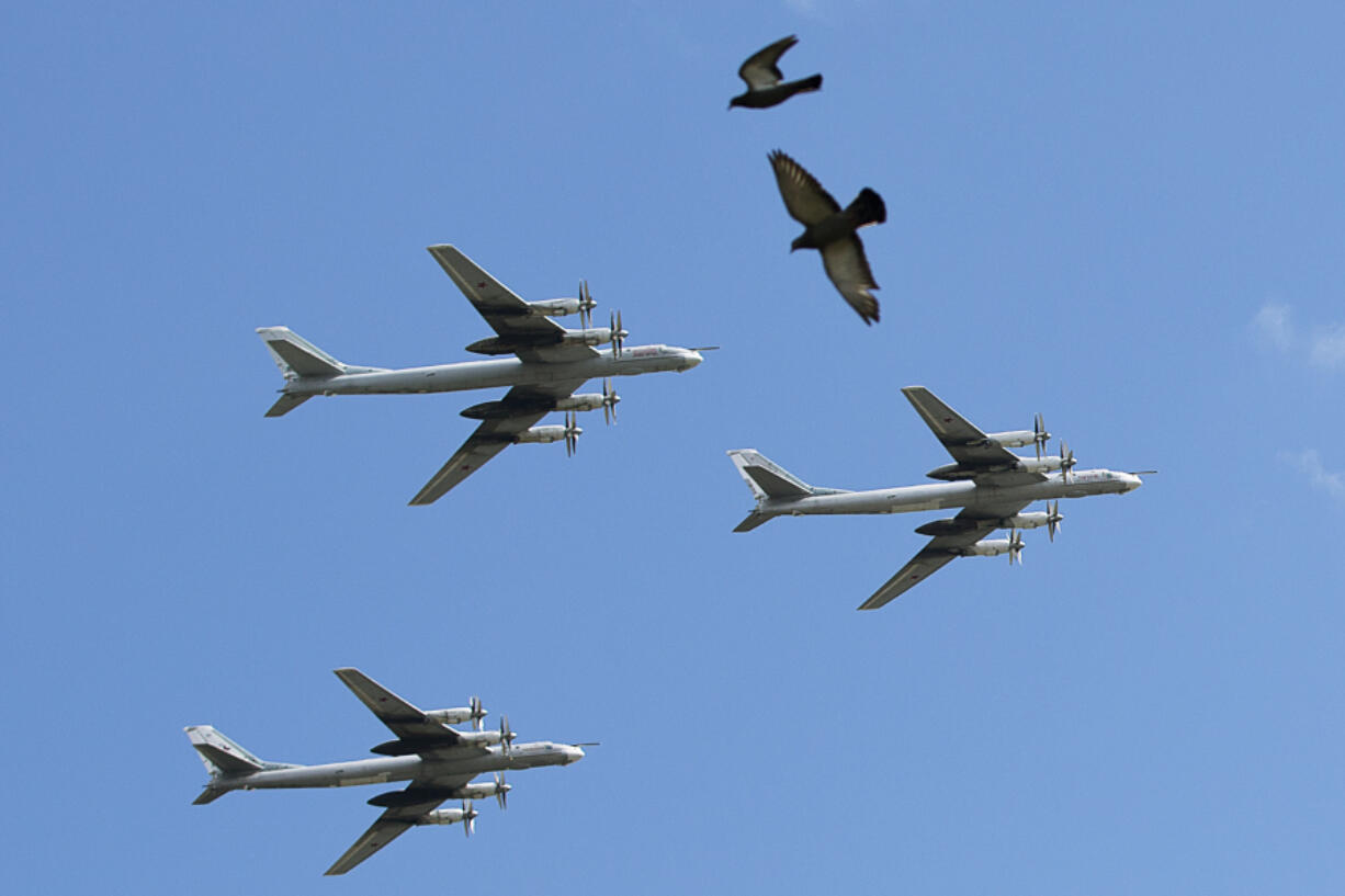 FILE - A trio of Tu-95 nuclear-capable strategic bombers of the Russian air force fly over Pushkin Square in Moscow, Russia, on May 3, 2014 during a rehearsal for the Victory Day military parade which will take place at Moscow&rsquo;s Red Square on May 9 to celebrate 69 years of the victory in WWII.